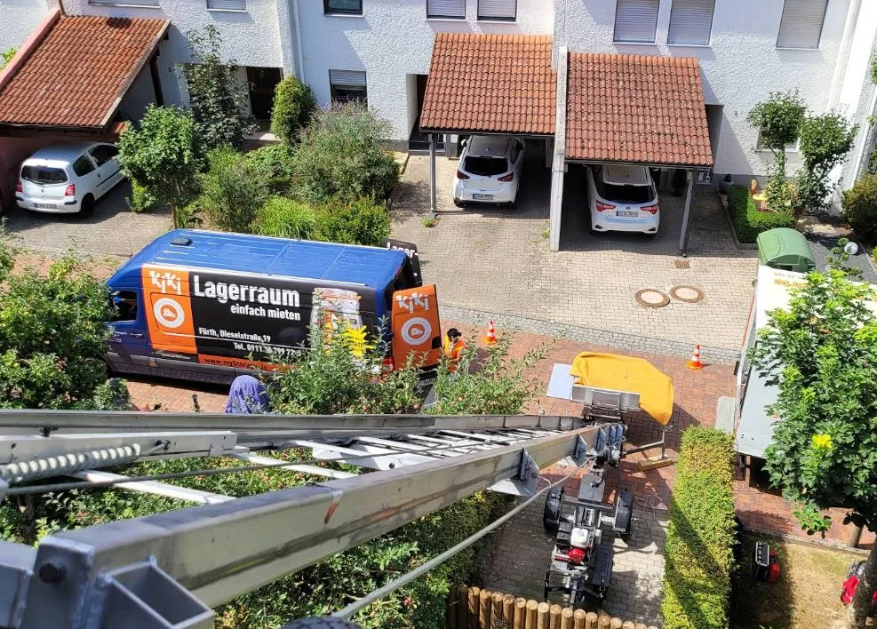Umzugswagen mit Mitarbeitern bei der Arbeit vor Wohnhäusern